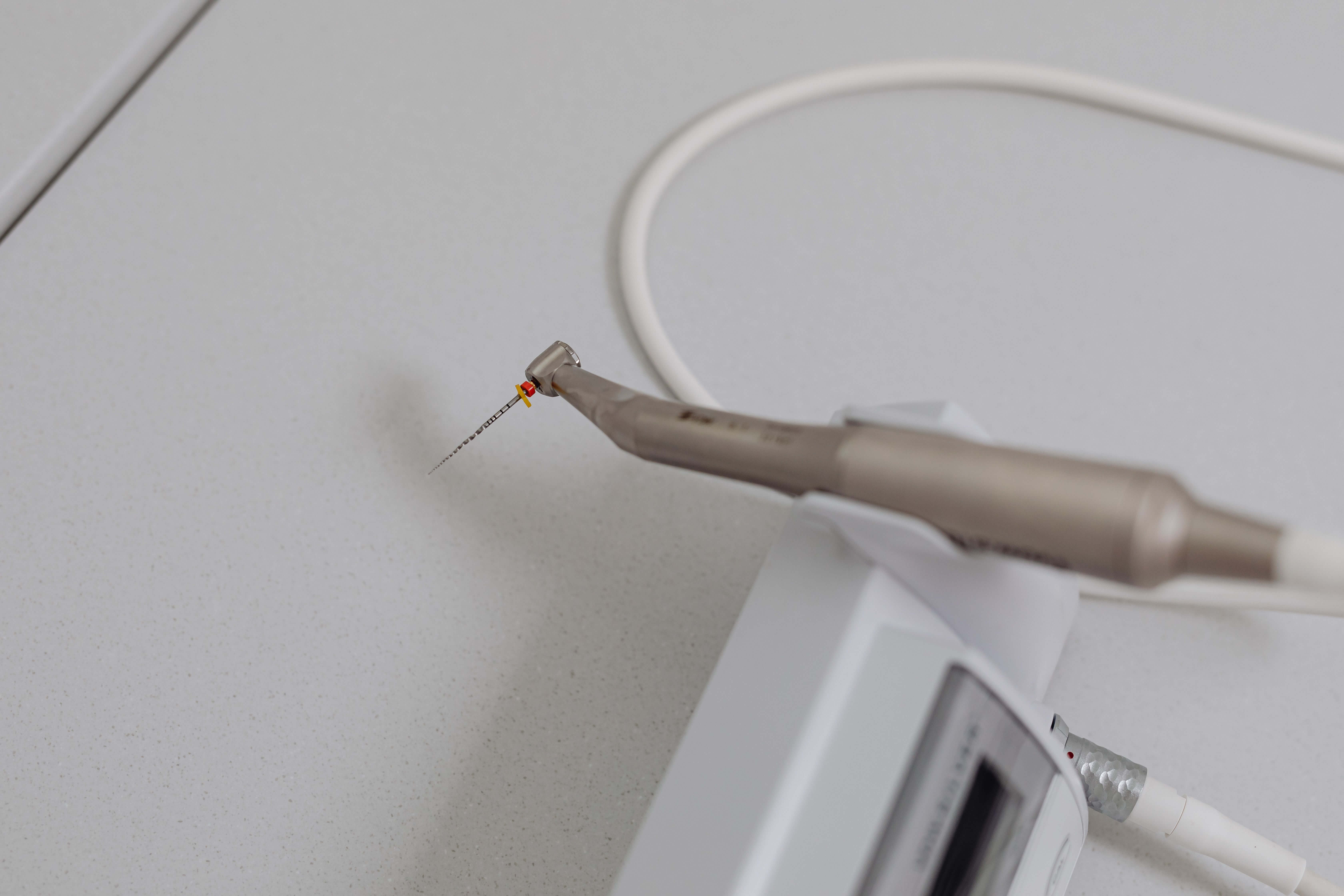 Close-up of a precision dental handpiece and endodontic file